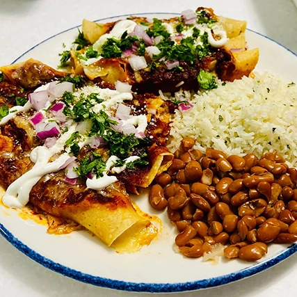 A plate of Mexican food with enchiladas, rice, and bean