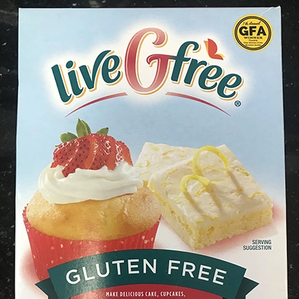 A box of "liveGfree" gluten-free baking mix with a cupcake and a lemon bar on the front.